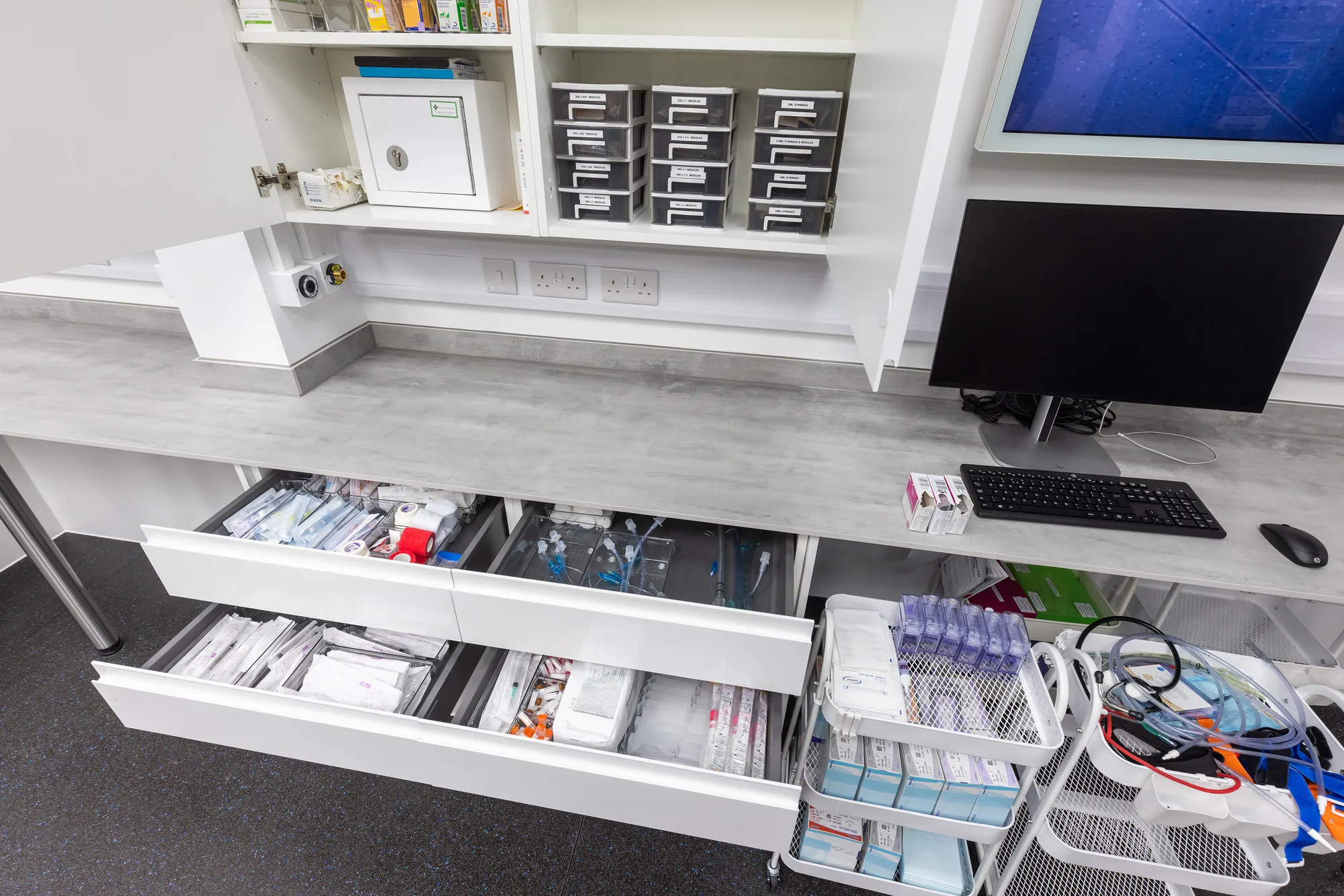 Fitted worktop at Vetemis Referrals, Brownhills, with drawer units of consumables, a wall cabinet and a controlled drugs cabinet