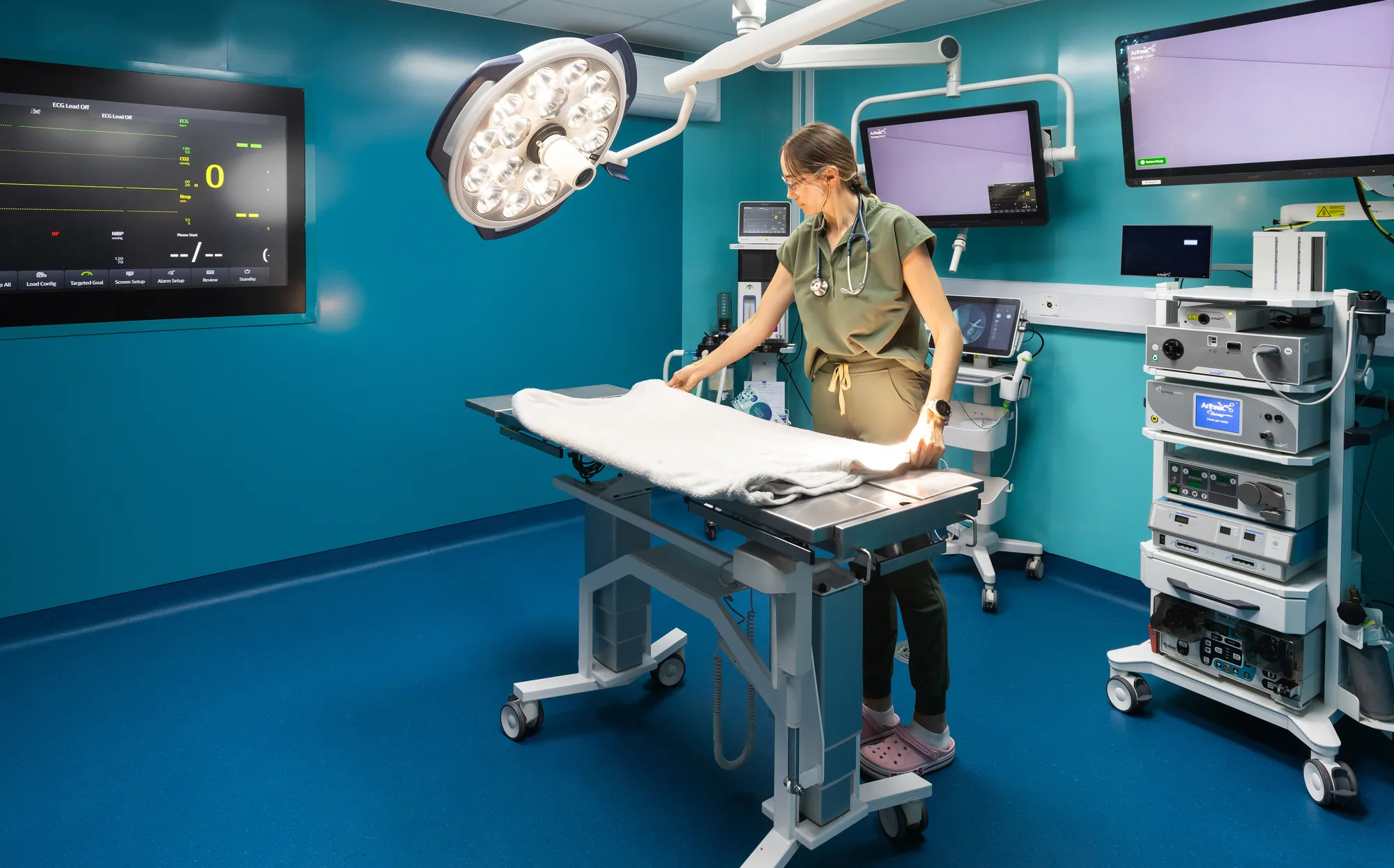 Operating theatre at Vetemis Referrals, Brownhills, being prepared, with the surgical light and ceiling pendant over the table and wall-mounted monitors behind