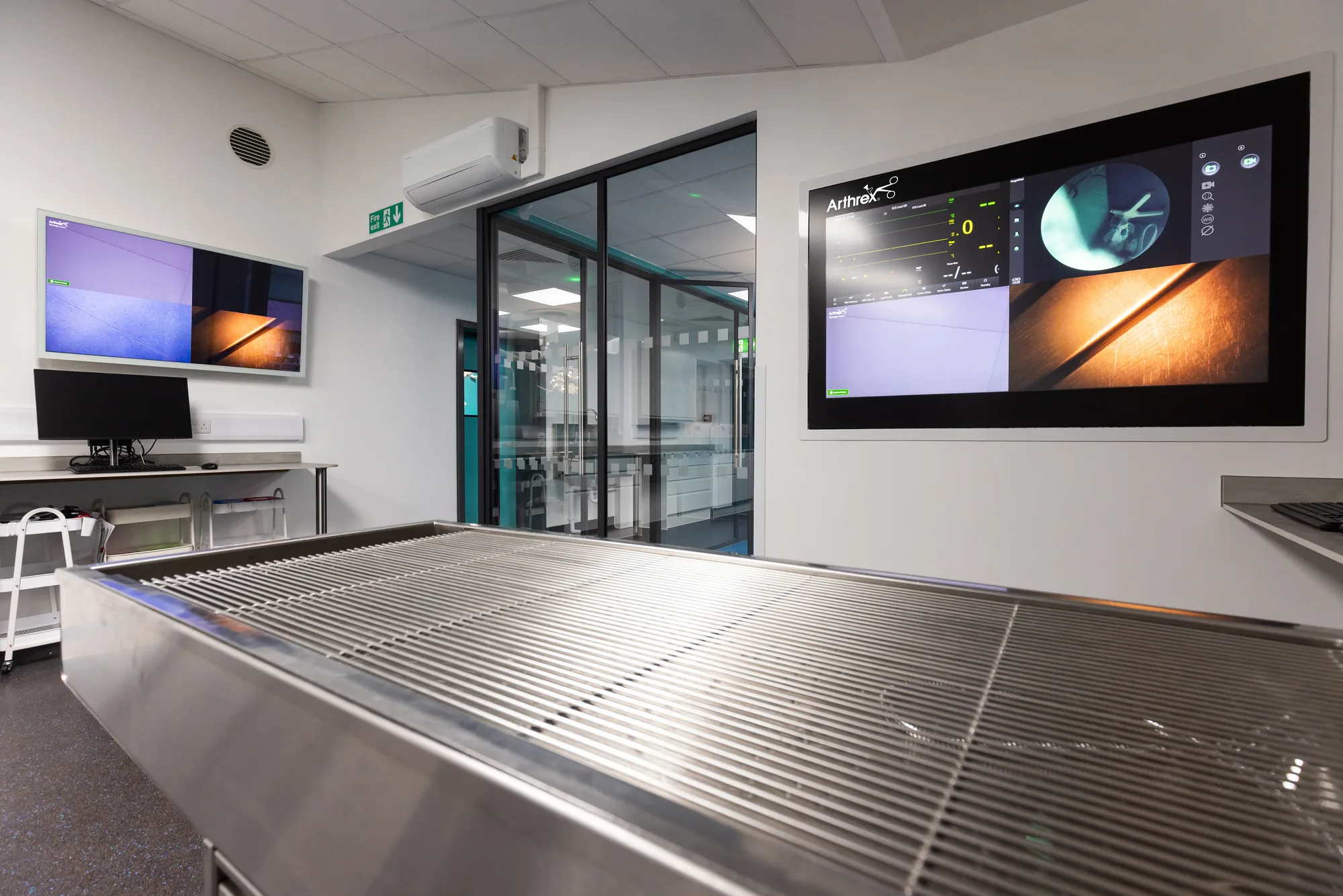 Stainless steel wet prep table at Vetemis Referrals, Brownhills, with the glazed partition through to the theatre suite behind it