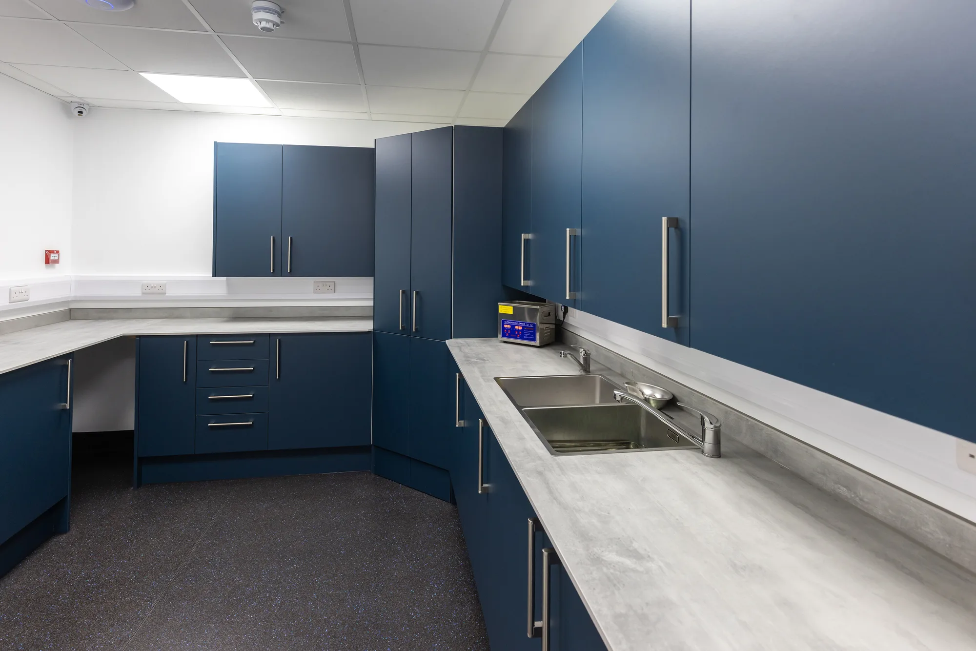 Utility room at Vetemis Referrals, Brownhills, with blue fitted cabinetry, worktop and clinical sink
